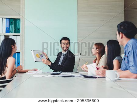 Manager holding papers hands and Smiling Professional team of coworlcers making great business discussion in modern office teamwork people.