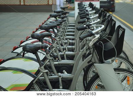 Many bicycles are lined up in a bicycle parking lot.