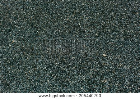 minimalism, trip, freespace concept. there is grey highly textured surface of almost black colour with little stones on or in it, fine background with negative space for text