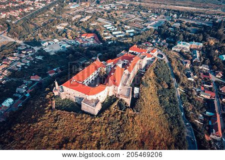 Beautiful panoramic view from the air to Palanok Castle at sunset and the city of Mukacheve