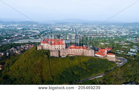 Beautiful panoramic view from the air to Palanok Castle at sunset and the city of Mukacheve