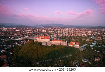 Beautiful panoramic view from the air to Palanok Castle at sunset and the city of Mukacheve