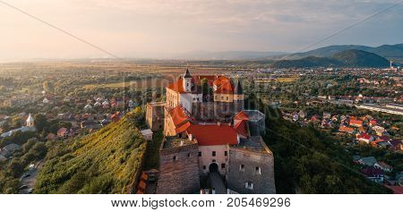 Beautiful panoramic view from the air to Palanok Castle at sunset and the city of Mukacheve