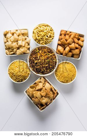 stock photo of Yellow Namkeen sev variety with shakkar para or shankar pale, Shakkarpare, Shakarpali served in white bowls arranged artistically, selective focus
