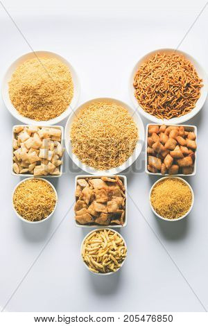 stock photo of Yellow Namkeen sev variety with shakkar para or shankar pale, Shakkarpare, Shakarpali served in white bowls arranged artistically, selective focus