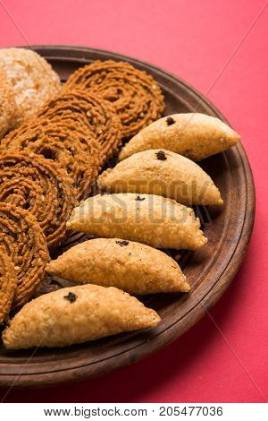stock photo of Indian festival or diwali food called chakli, anarsa and karanji or Gujiya, selective focus