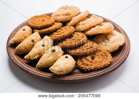 stock photo of Indian festival or diwali food called chakli, anarsa and karanji or Gujiya, selective focus