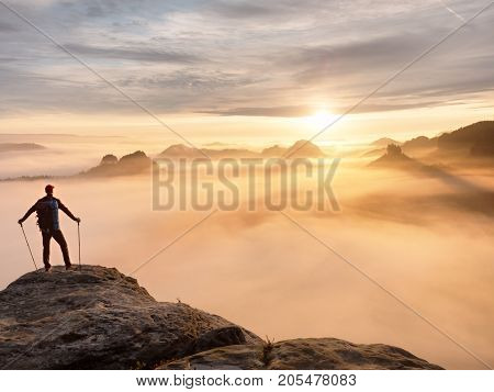Man Silhouette With Poles In Hand. Sunny Spring Daybreak And Tourist Guide Stay On Sharp Cliff Of Mo