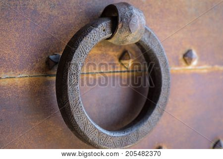 Closeup vintage door knocker of rusty iron door