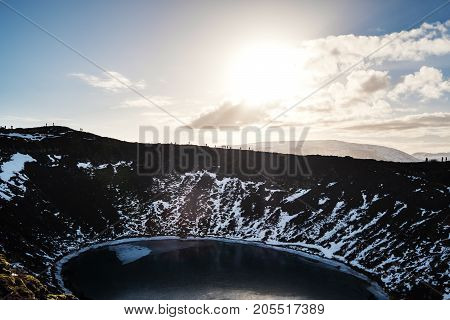 Landscape Kerio Crater Lake, with silhouette people trekking against bright sunlight
