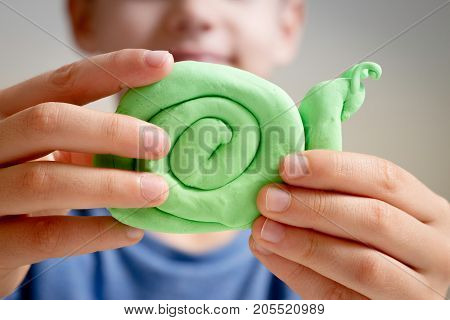 Kids hands making toy figure with modeling clay or plasticine