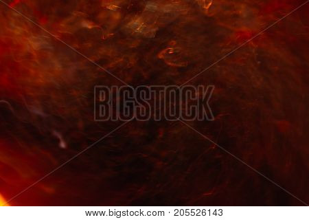 Abstract background of colorful crankles in motion on black. Bokeh of defocused curves, blurred neon yellow and red leds, hellfire and storm, abyss and seven circles of hell