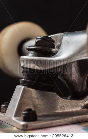 Close up of skateboard parts on black background. Safety construction of professional extreme sport devices and skateboarding elements. Kingpin, bushing, hanger, wheel