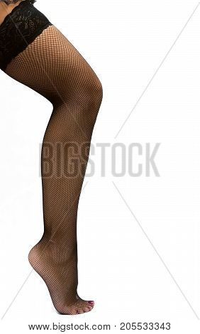 Sexy female legs in fishnet pantyhose stockings standing on toe cap isolated.
