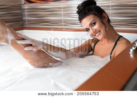 Pretty sexy brunette in green bicini shot in sauna