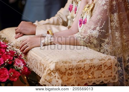 Bride and groom hands in water relaunch ceremony. Thai traditional wedding. Selective focus and shallow depth of field.