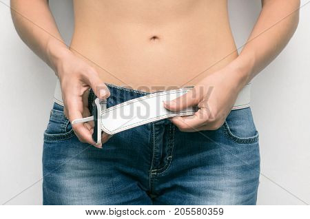 Waistline of woman body. Girl buckles the belt close up. Sport gym diet.