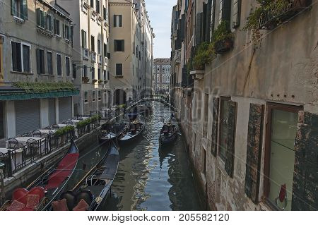 Venice, Italy - September 23, 2011: Traditional gondola ride in small canal at residential district of historical buildings and bridge, Venezia, Venice, Italy, Europe . Visit in place.