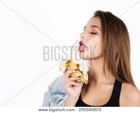 Young sensual woman eating banana on white background. provocation concept. on a white background.