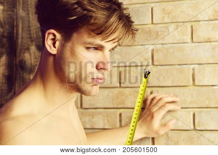 Man With Naked Body Holds Yellow Self Retracting Tape Measure