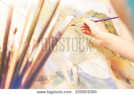 Creativity has no boundaries. Selective focus on a hand of an artist holding a painting brush and creating a new abstract masterpiece on an art canvas.