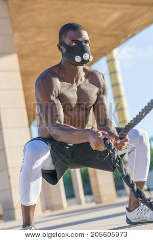 Male Muscular Training With Battle Ropes And Training Mask