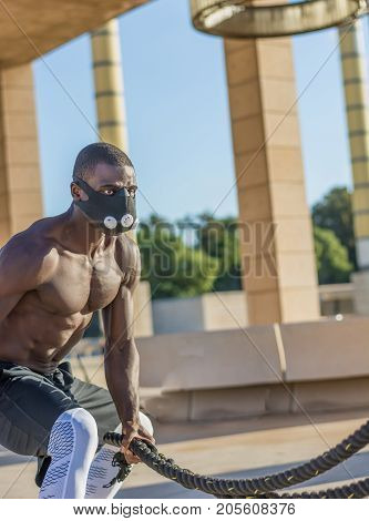Male Muscular Training With Battle Ropes And Training Mask