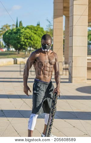 Male Muscular Training With Battle Ropes And Training Mask