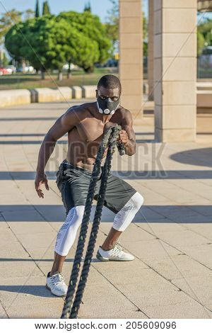 Male Muscular Training With Battle Ropes And Training Mask