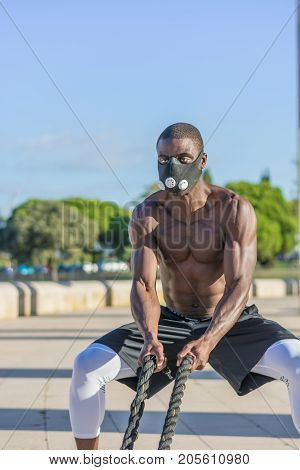 Male Muscular Training With Battle Ropes And Training Mask