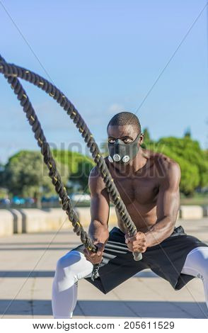 Male Muscular Training With Battle Ropes And Training Mask