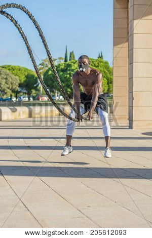 Male Muscular Training With Battle Ropes And Training Mask