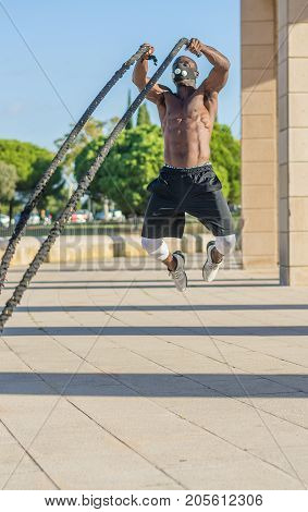 Male Muscular Training With Battle Ropes And Training Mask
