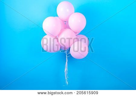Pink birthday balloons on blue (cyan) background with copy space for text. Pink pastel party balloons free space. Love happiness valentine wedding honeymoon concept. Happy holiday flying balloons