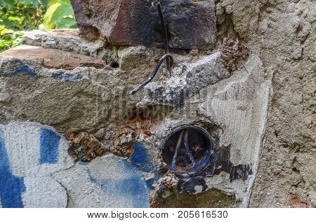 A fragment of an old destroyed wall and an electrical outlet in it. Abandoned building. Old architecture
