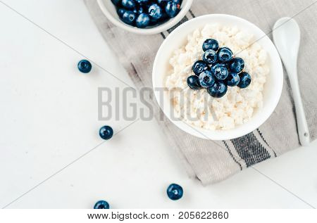Fresh cottage cheese with blueberries on wood white
