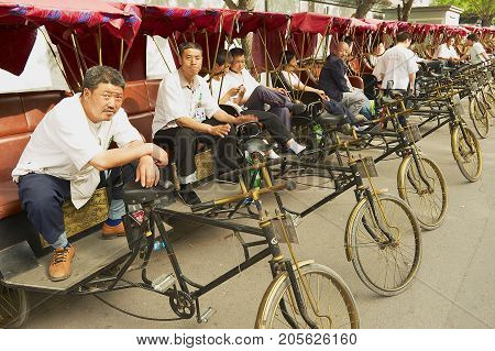 BEIJING, CHINA - MAY 01, 2013: Unidentified rickshaws wait for passengers at Futong street next to the Houhai lake in Beijing, China.