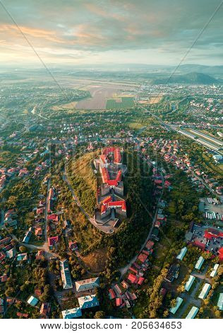 Beautiful panoramic view from the air to Palanok Castle at sunset and the city of Mukacheve
