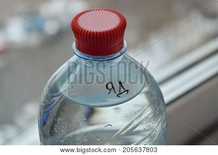 A one-and-a-half-liter bottle with poison and an inscription of poison on the Cyrillic alphabet stands on the windowsill near the window.