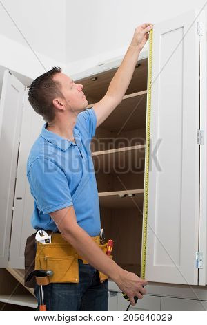 Carpenter Installing Luxury Fitted Kitchen In Home
