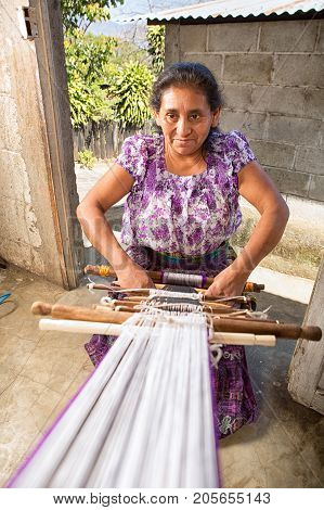 January 20 2015 San Pedro la Laguna Guatemala: mayan woman weaving a yarn belt with traditional wooden sticks