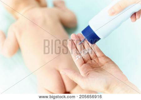 Mom Applying Talc Powder From Plastic Tube To The Baby Body