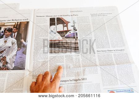 PARIS FRANCE - SEP 25 2017: Man reading German newspaper about Siemens and Alstom possible merger