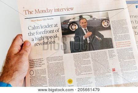 PARIS FRANCE - SEP 25 2017: Man reading international newspaper Financial Times with Oliver Blume Porsche CEO