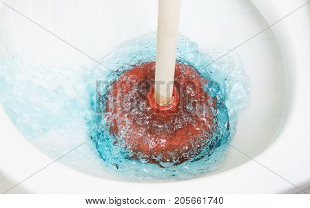 a close up of a plunger in a toilet.