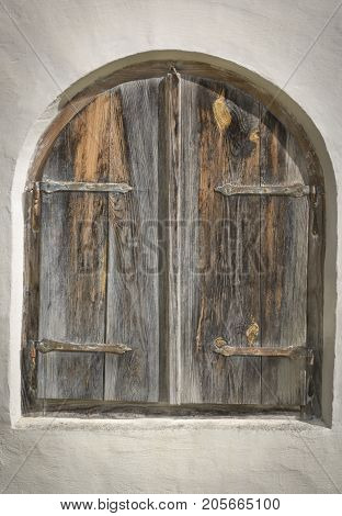 Closed a window by a wooden old storm-shutters