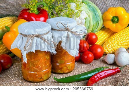 jars with winter supplies, banks with salad are on the table with vegetables