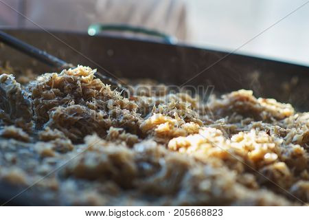 Freshly prepared juicy traditional Bavarian cabbage in a large frying pan during the octoberfest season. Soft focus and backlight.