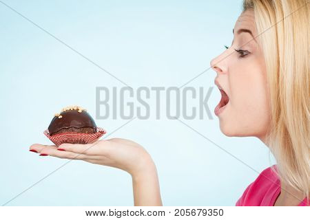 Woman Holding Chocolate Cupcake About To Bite
