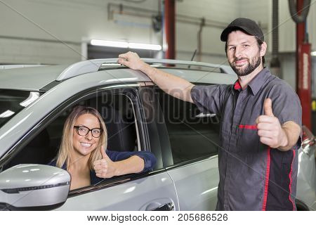 An auto mechanic and female customer in garage